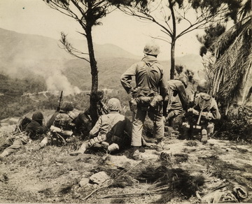 PFC Harby (center kneeling) observing artillery barrage